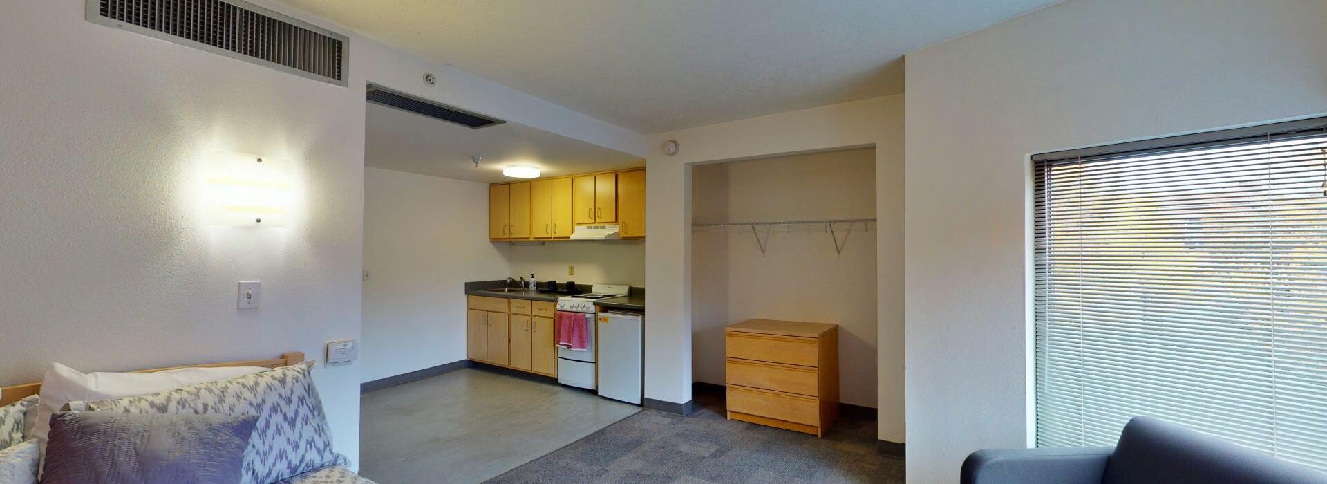 Interior shot of the Gem studio room with kitchenette and closet.
