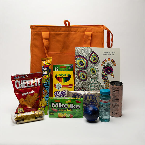 snack bag including can drink, bubbles, stress ball, chips, chocolate, crayon, fruit roll, popcorn, sweets.