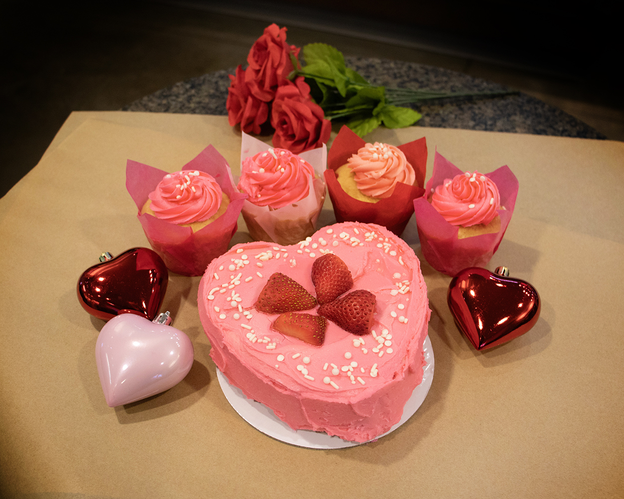 pink cake and frosted cupcakes